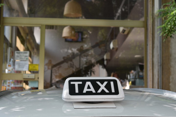 Insegna sul tettuccio di un taxi vicino a una vetrina
