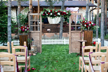 Fototapeta na wymiar Outdoor wedding ceremony, chairs decorated with flowers on the grass