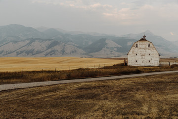 Old White Barn in Front of Beautiful Mountain Scenery
