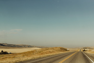 Fototapeta na wymiar Open Highway Stretching Along Farmlands of Bozeman, Montana