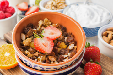 Healthy paleo gluten free nut and fruit granola served with fruits and berries, nut milk, coconut yogurt, selective focus