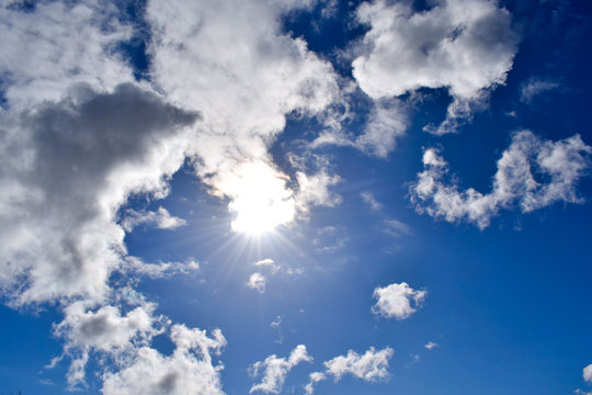 Cloudy sky on a spring day. The sun is visible through the cloud. © AntiD