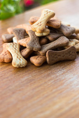 Dog tasty colored biscuits on wooden background 
