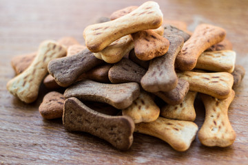 Dog tasty colored biscuits on wooden background 