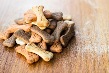 Dog tasty colored biscuits on wooden background 