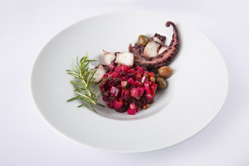 Salad from beet and octopus. Vinegret is a traditional Russian salad made from beets and vegetables. The background is white. Copy space. Horizontal shot.