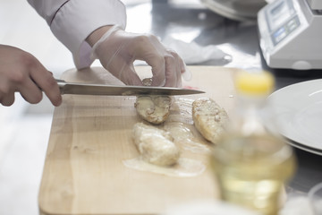 Chef in hotel or restaurant kitchen cooking, only hands.