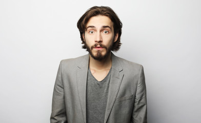 lifestyle, fashion and people concept: Portrait of young man posing over white background