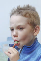 the boy eats Lollipop intently
