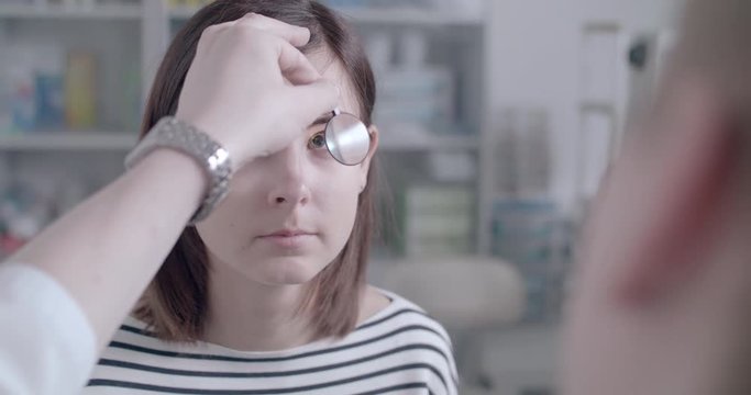 Ophthalmologist checks woman's eyes