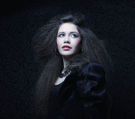 Beautiful young woman with curly hair and evening make-up. Jewelry and Beauty concept. Fashion art photo.