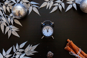 Christmas New Year Composition winter objects clock silver branch, baubles and balls on dark black...