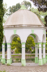 White gazebo in the green summer park