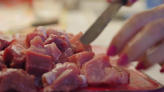 Elderly Woman Hands Cutting Meat With A Knife