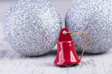 Weihnachtsmotiv mit goldener und roter Glocke auf weißem rustikalen Holz Hintergrund