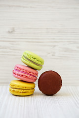 Sweet and colorful macaroons on a white wooden background, side view. Close-up.