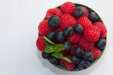 Raspberries and blueberries in a bowl.