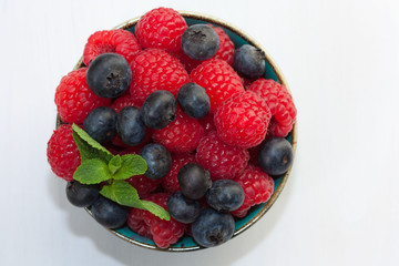 Raspberries and blueberries in a bowl.