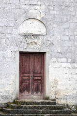 Fototapeta na wymiar Ancient wooden door in stone castle wall.