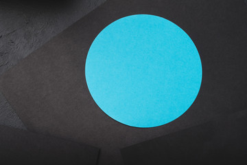 paper layers. contrast of black sheets and blue circle. minimalistic abstract background with copyspace.