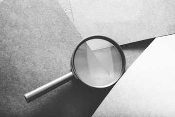 magnifier on grey layered paper background. searching seeking looking recruiting and headhunting concept. - obrazy, fototapety, plakaty