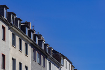 Fototapeta na wymiar Eine ganze Reihe Dachgeschosswohnungen und blauer Himmel in Düsseldorf