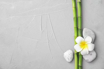 Zelfklevend Fotobehang Composition with bamboo branches, stones and plumeria on light background, top view. Space for text © New Africa
