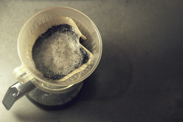 Vintage style of coffee in the morning. Close up of ground coffee in a dripper while making aroma espresso.