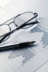 Fountain Pen And Glasses On Financial Graphs Close-up