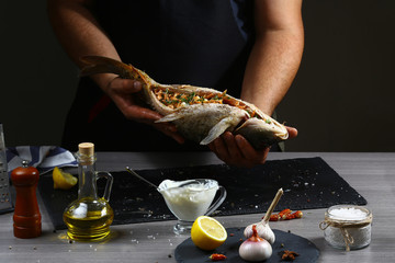 Stuffed fish carps are ready for baking in the hands of the cook, cooking recipe. Authentic lifestyle image. Top flat view, from above