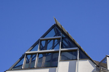 Lichtdurchflutete Dachgeschosswohnung mit vielen Fenstern und blauer Himmel