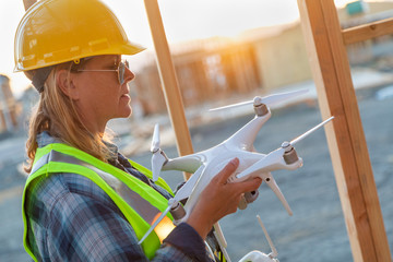 Female Unmanned Aircraft System (UAS) Quadcopter Drone Pilot Holding Drone at Construction Site