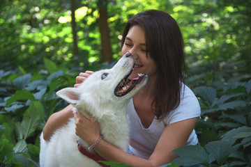 Young woman hugging and tapping her dog