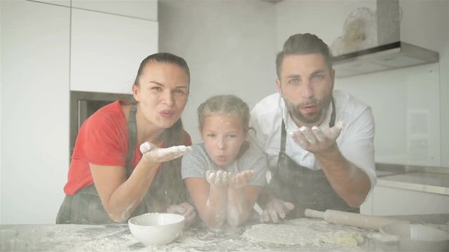 Funny Family Having Fun In The Kitchen. They Blow The Flour From Their Hands. It Looks So Cute.