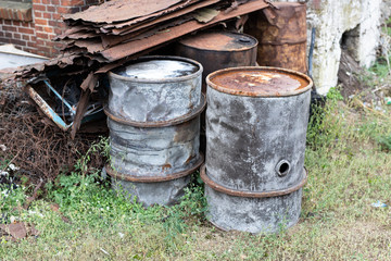 Obraz premium Old barrels for diesel. Metal containers for oil standing on the scrap yard.