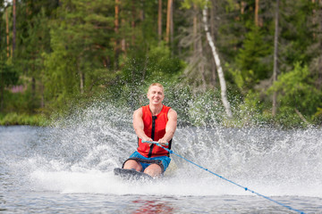 Young athletic man riding kneeboard on a lake