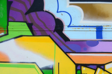 Fragment of graffiti drawings. The old wall decorated with paint stains in the style of street art culture. Multicolored background texture