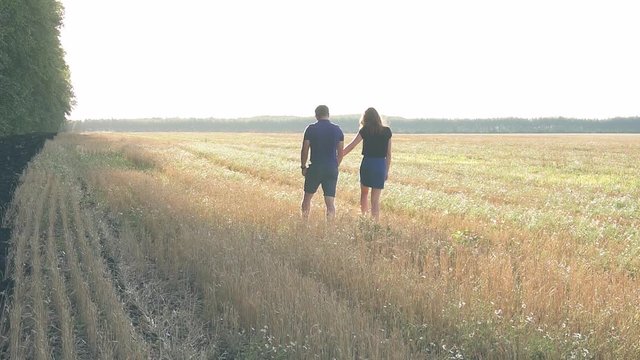 young loving couple in nature in summer on a background of field with oats, there is noise on the video