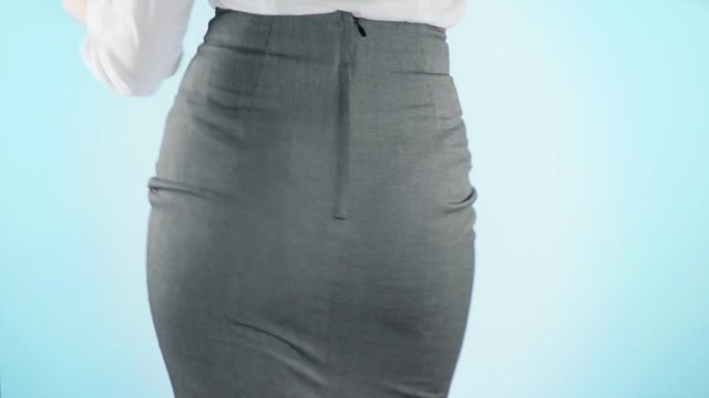 Beautiful business woman on a colored background. close-up skirt. dress code, move the hips. 4k, slow motion
