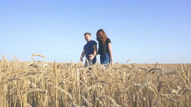 young loving couple in nature in summer on a background of field with oats, there is noise on the video