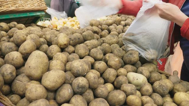 A woman in a supermarket buying vegetables