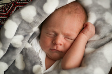 Sweet sleeping newborn baby in gray plaid, real