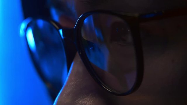 Programmer's eye with glasses sitting at computer