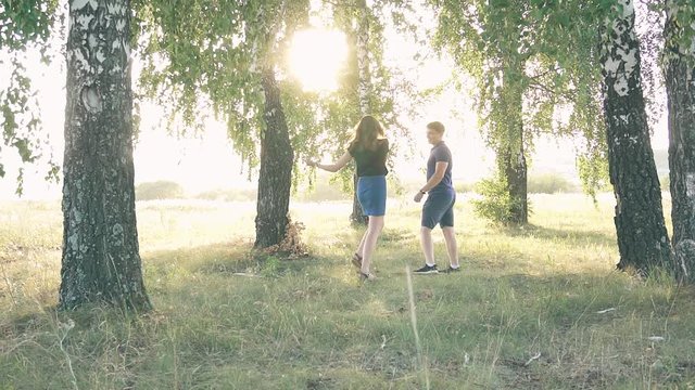 young loving couple in nature in summer on a background of leaves , there is noise on the video