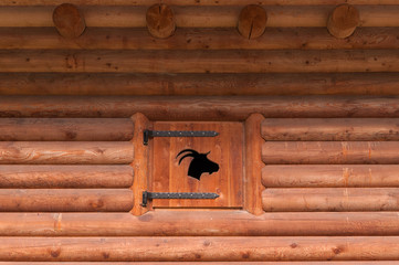 Wall of mountain cabin in wood with inlaid wooden window closed