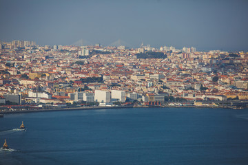 Fototapeta na wymiar Beautiful super wide-angle panoramic aerial view of Lisbon, Portugal with harbor and skyline scenery beyond the city, shot from belvedere observation deck of Cristo Rei