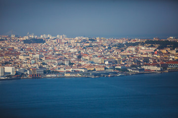 Obraz premium Beautiful super wide-angle panoramic aerial view of Lisbon, Portugal with harbor and skyline scenery beyond the city, shot from belvedere observation deck of Cristo Rei