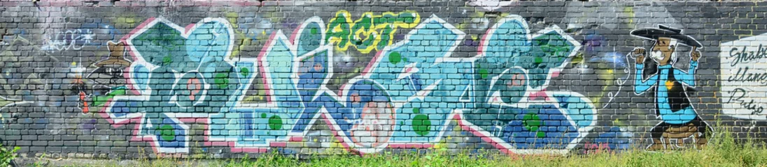 Fragment von Graffiti-Zeichnungen. Die alte Wand ist mit Farbflecken im Stil der Straßenkunstkultur dekoriert. Farbige Hintergrundtextur in Grüntönen © mehaniq41