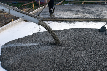 Workers pour the Foundation for the construction of a residential building using mobile concrete...