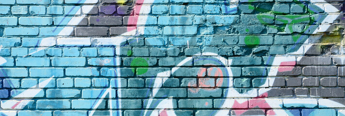 Fragment of graffiti drawings. The old wall decorated with paint stains in the style of street art culture. Colored background texture in cold tones